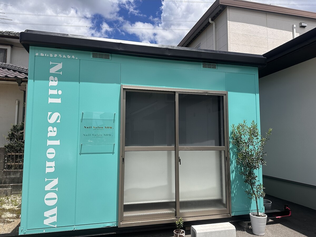 ターコイズの建物に白い店名の看板。お店の外観